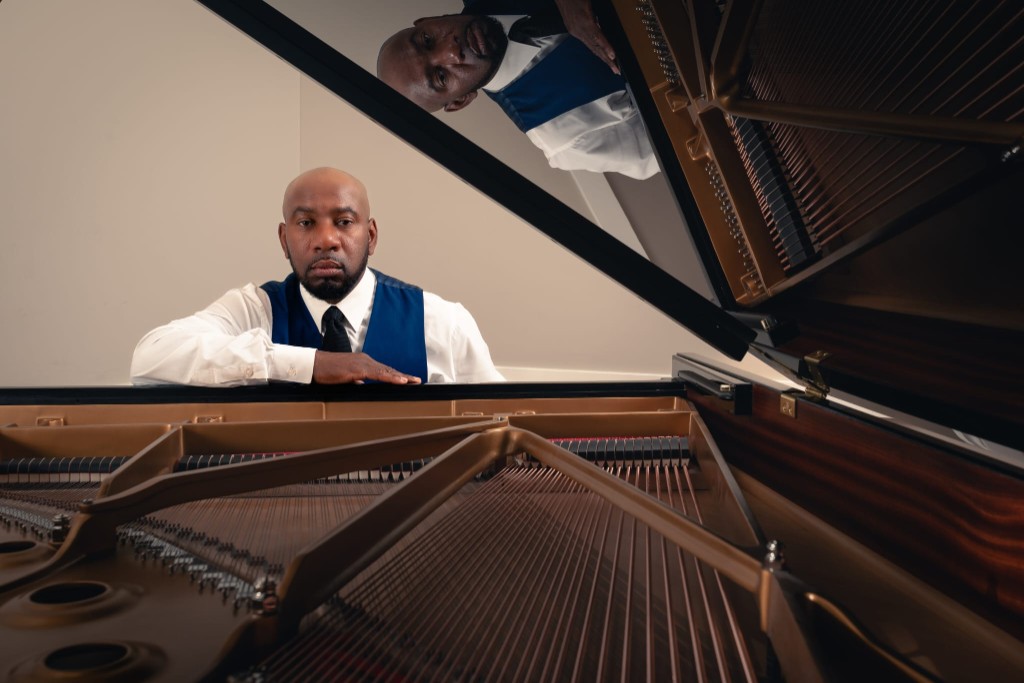 Johnson Philip seated at an open grand piano